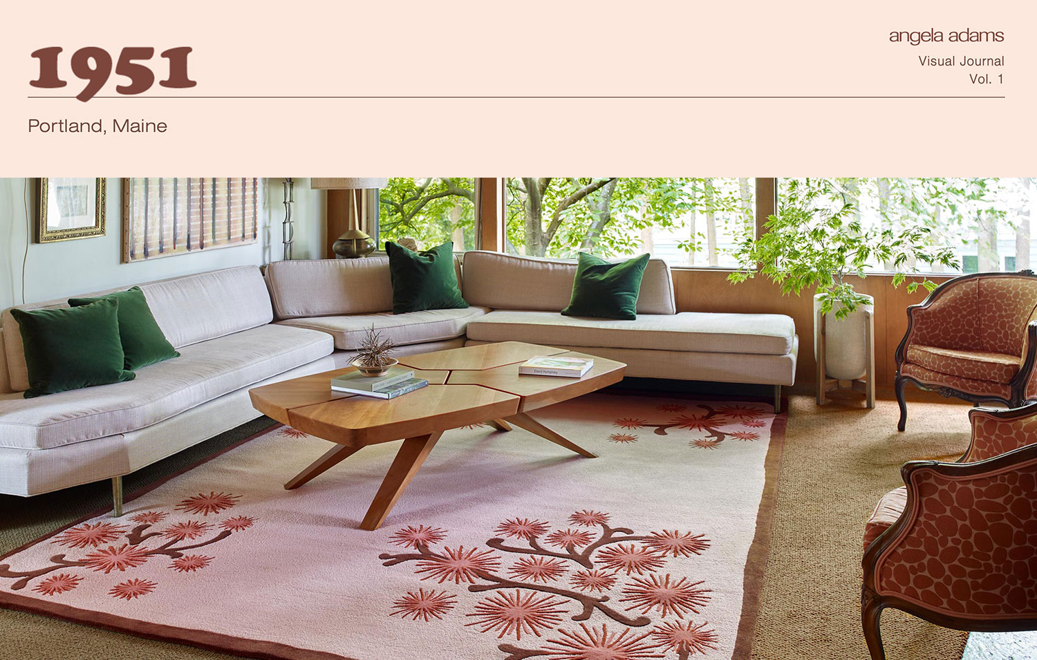 A retro 1951 looking room with pink rug, and abstract pattern on it surrounded by low slung couches.