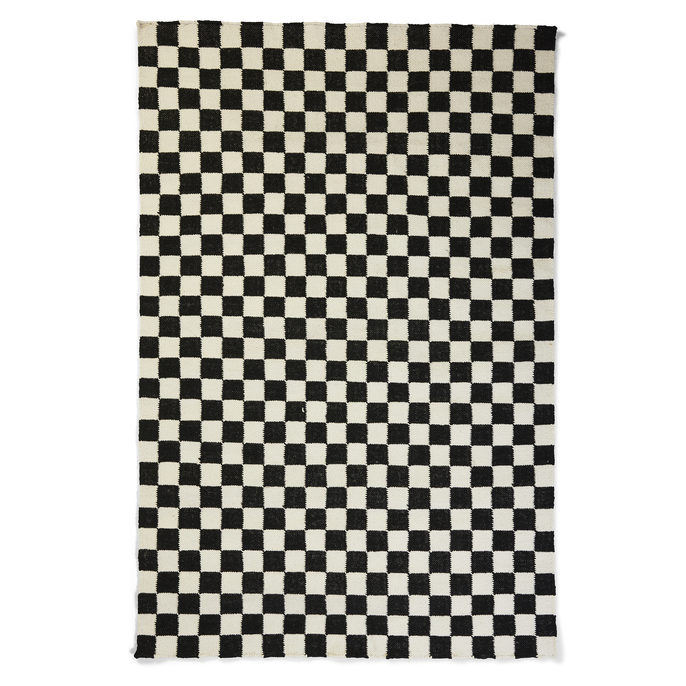 A rectangular area rug featuring a bold, high-contrast, black and white checkered pattern composed of small squares. The pattern covers the entire surface of the rug. The texture appears to be woven, possibly wool or a similar fiber, giving the squares a slightly softened, hand-crafted look rather than a sharp, printed graphic. The edges of the rug are visible, showing a simple, woven finish. The rug is isolated on a plain white background.
