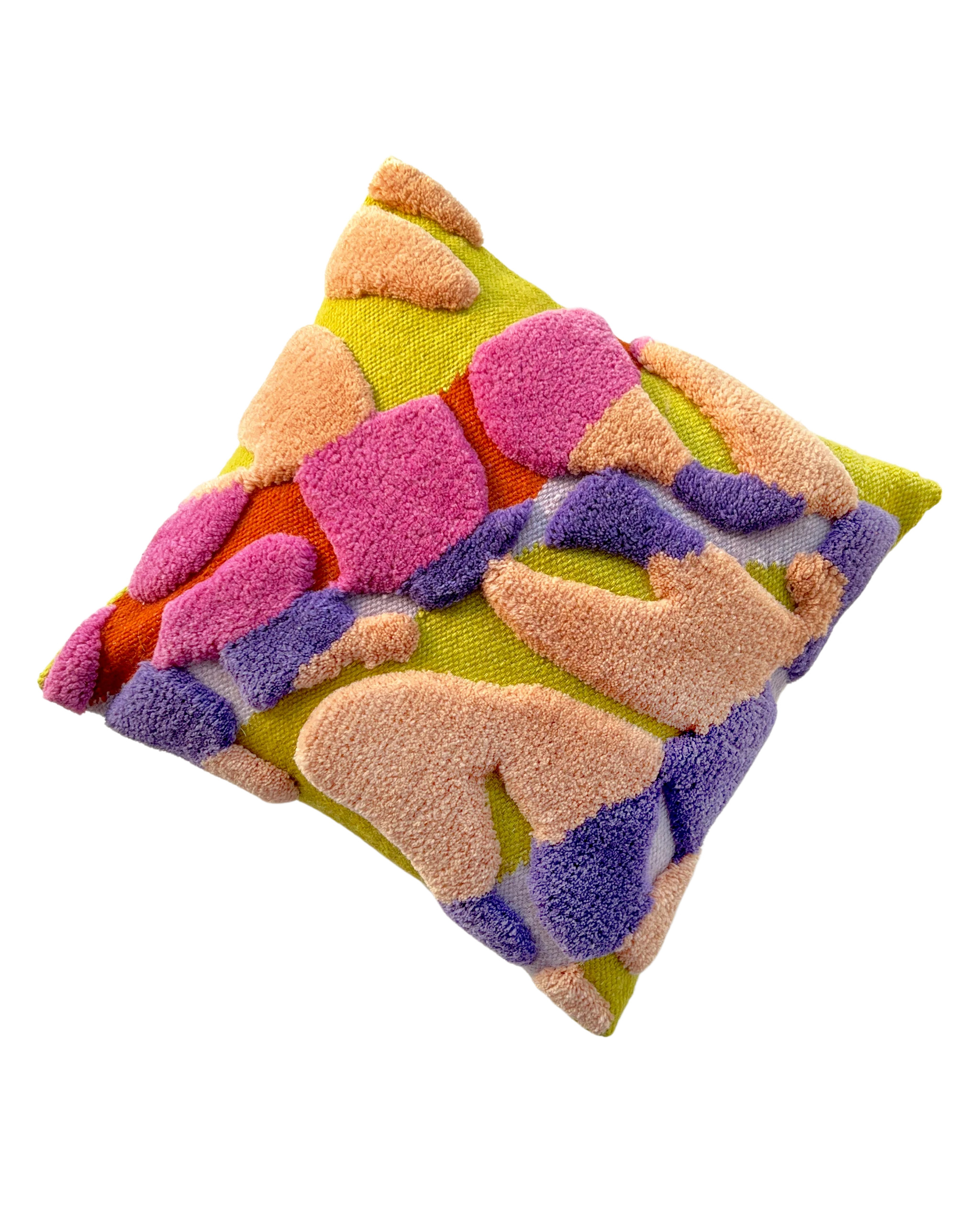 A square decorative throw pillow is shown angled, presenting a three-dimensional, fluffy texture. The base fabric of the pillow is a bright, chartreuse yellow-green. This base is covered with a highly textured, abstract, or camo-style pattern made of tufted, raised loops of yarn in several colors: Peachy-orange (lightest color) Hot pink (magenta) Deep purple Bright orange-red The pillow is set against a plain, light-gray background, making the vibrant colors and raised textures stand out. The textile technique appears to be a form of tufting or punch-needle embroidery.