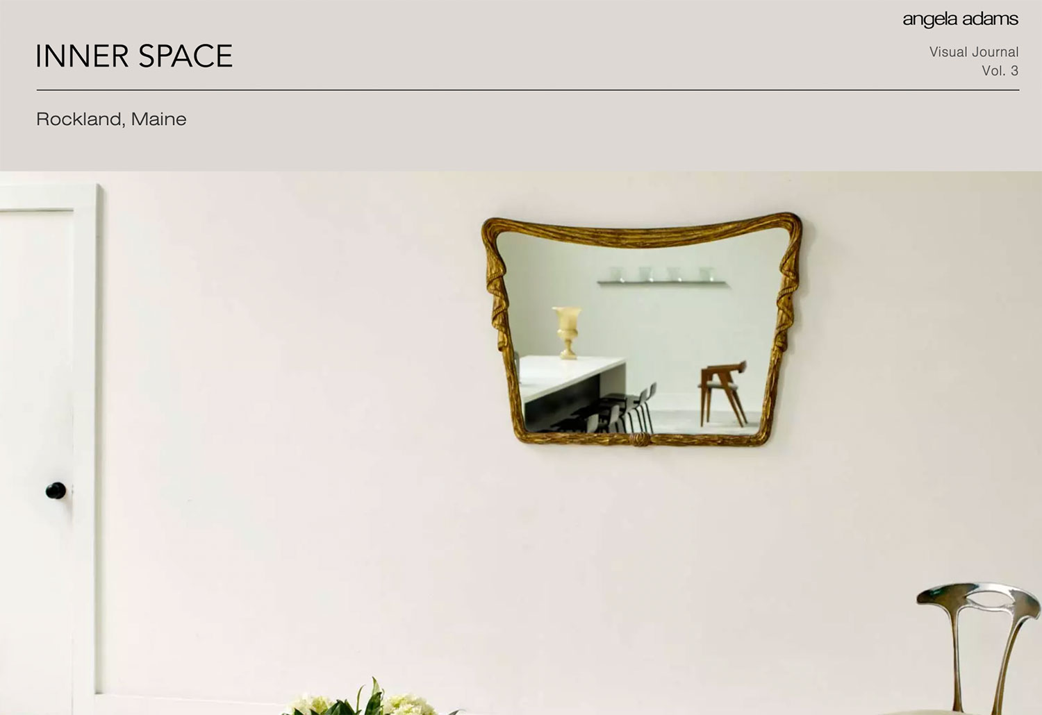 A mirror on a wall with modern spacious furniture.