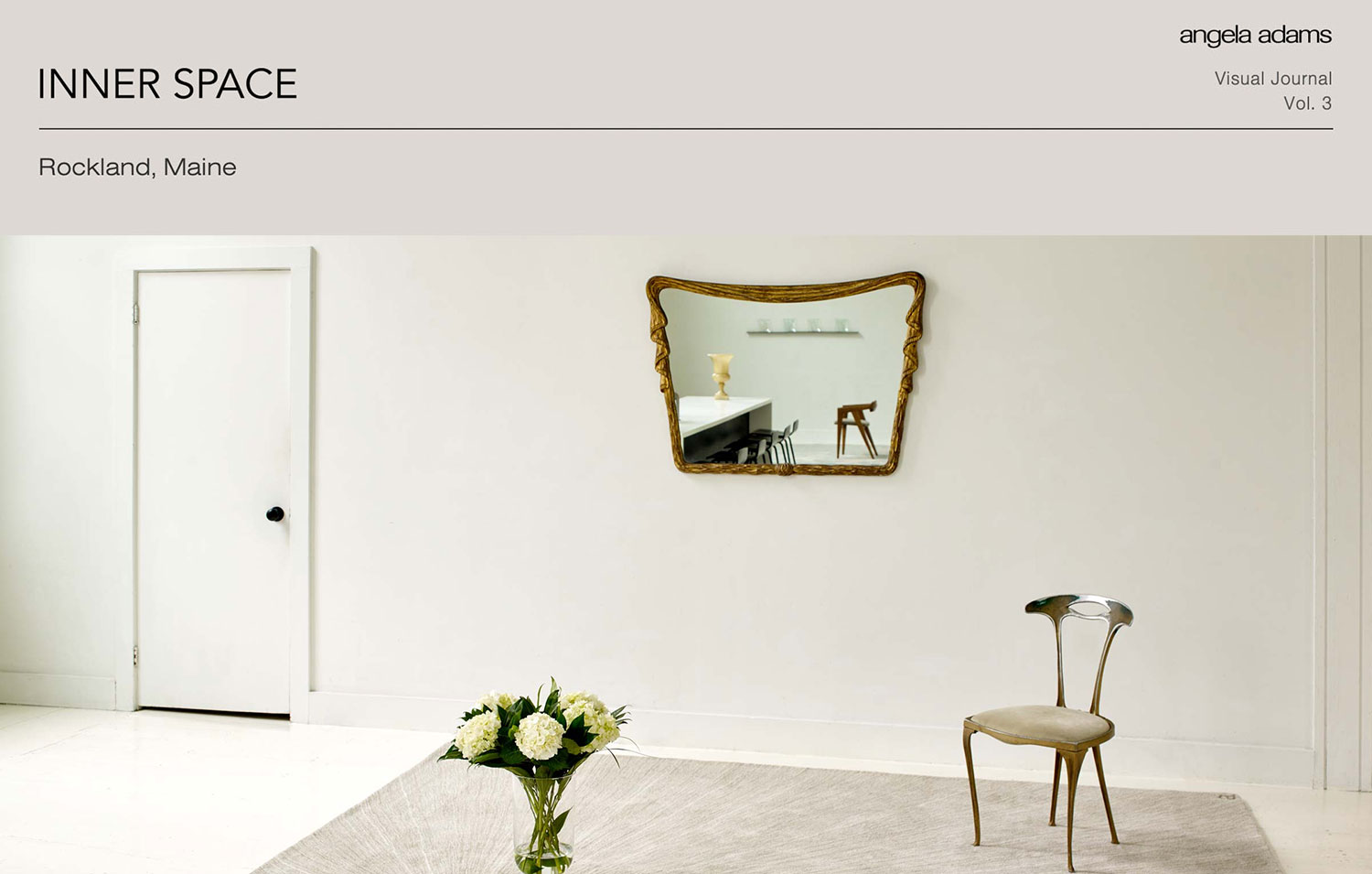 A spare room with white door, walls and mirrors and a gray and white plush rug across the middle.