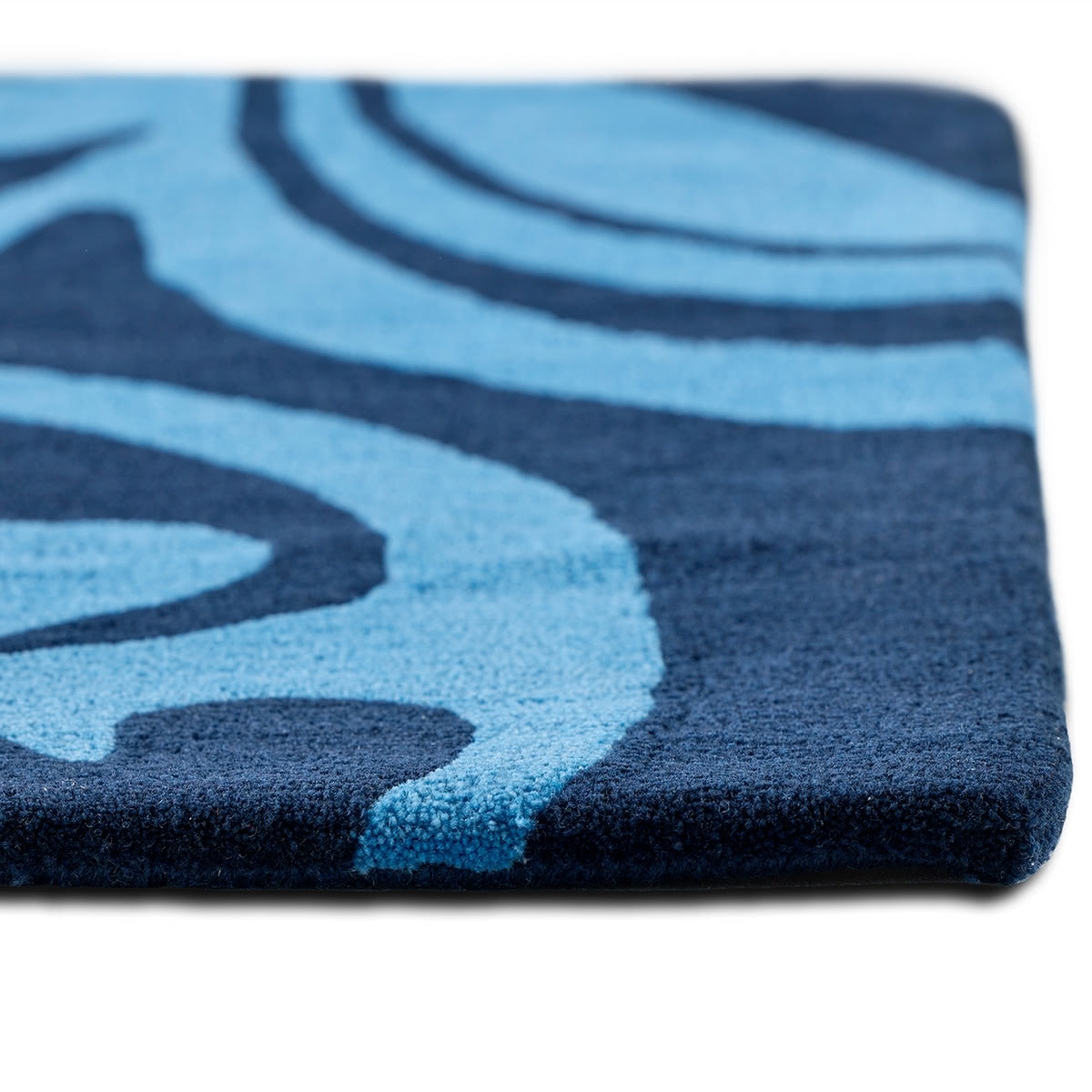 The corner of an abstract blue flower rug.