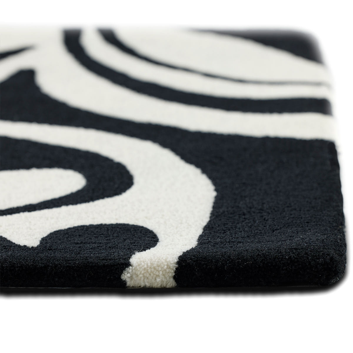 The corner of an abstract black and white flower rug.