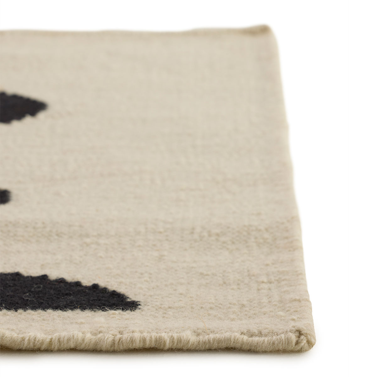 The corner detail of an abstract rug with a yellow sunshine and a black heart named Sunshine Love.