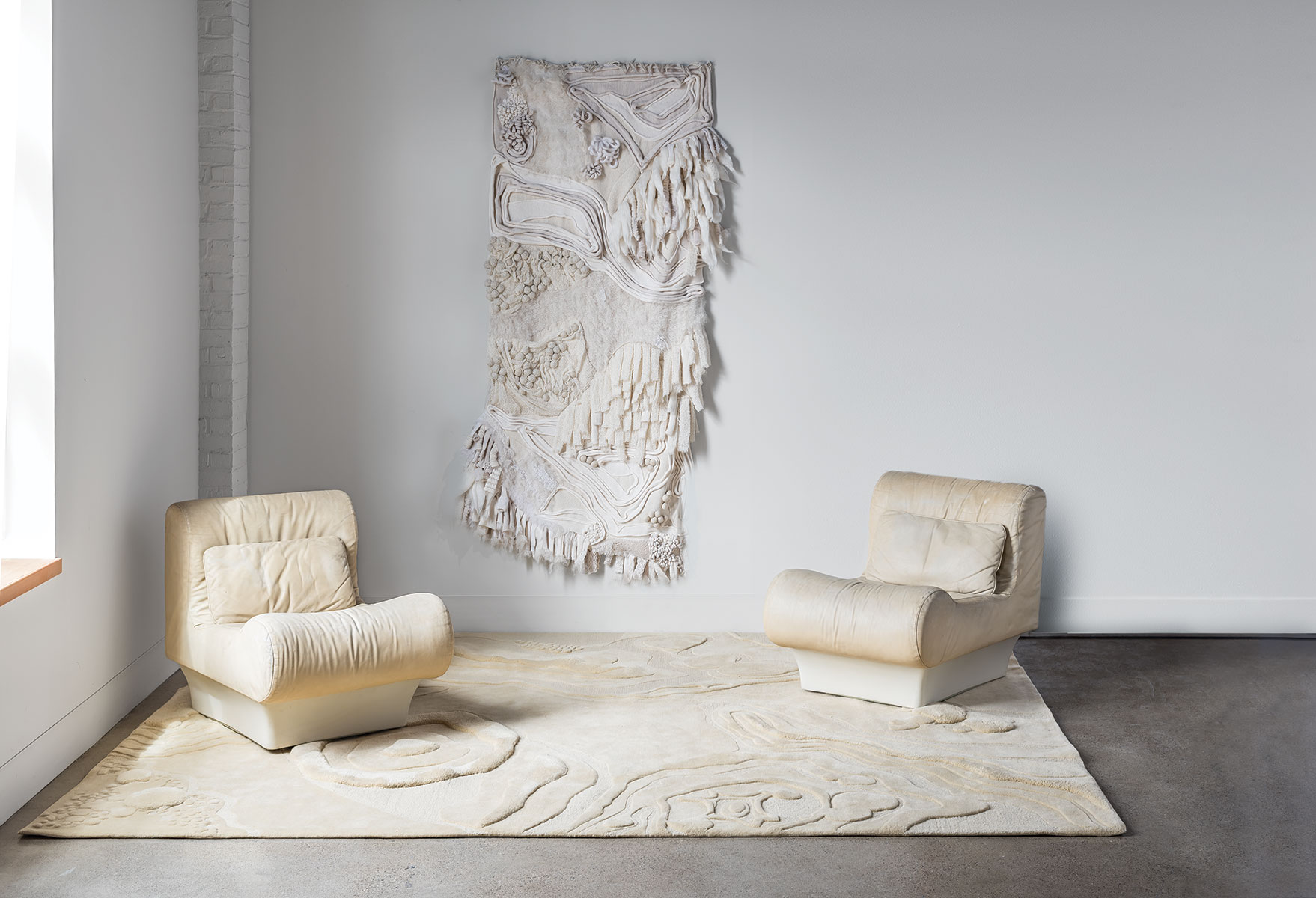 Two chair sit on top of an organic patterned rug called Nebula