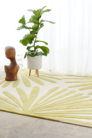 A white room with wicker chair, and plant on a modern area rug called Daisies Sunny