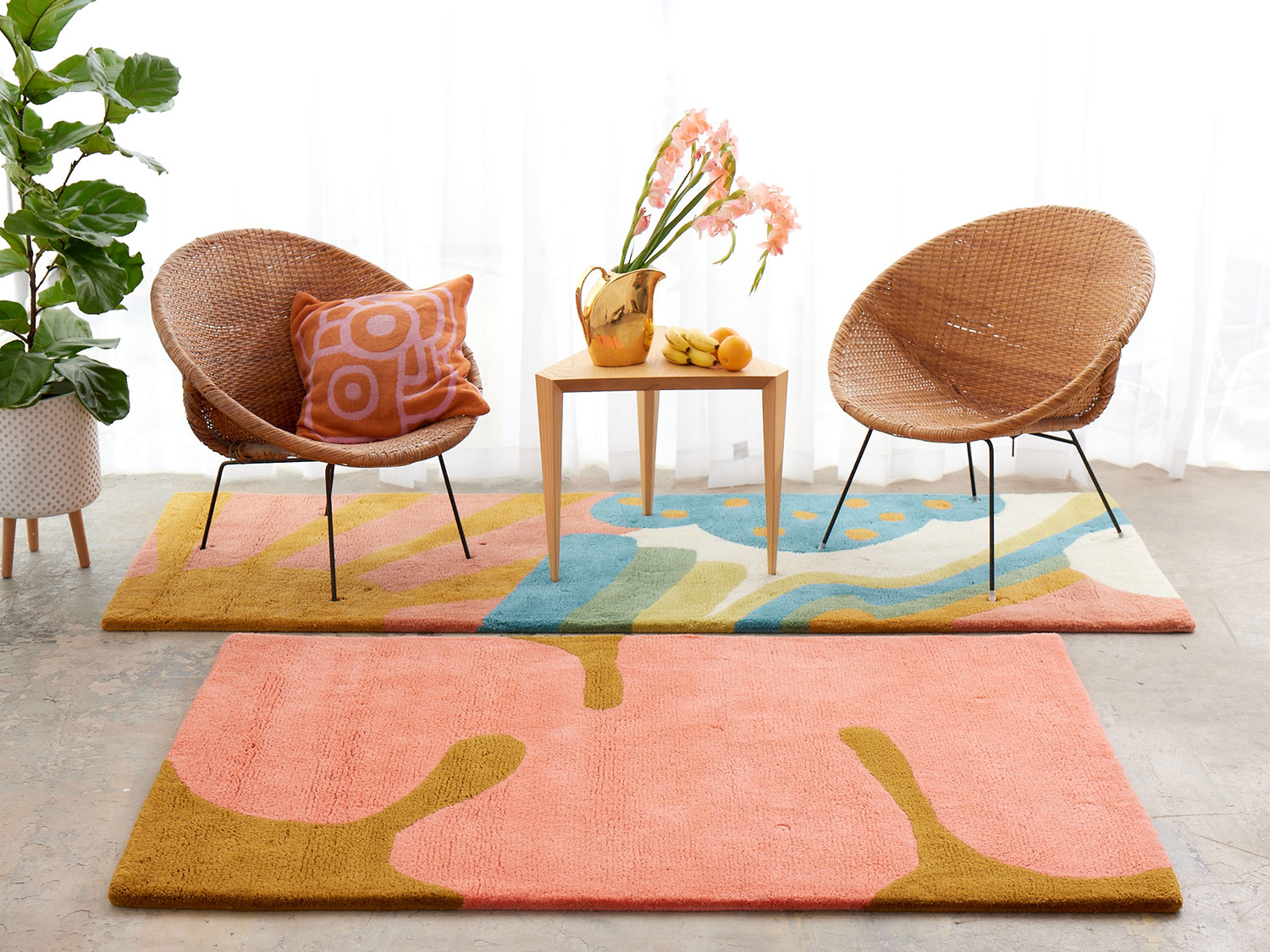 shine-angela-adams-daytrip-happy-hero A white room with wicker chairs on a multi-colored, modern area rug by Angela Adams called Daytrip Happy