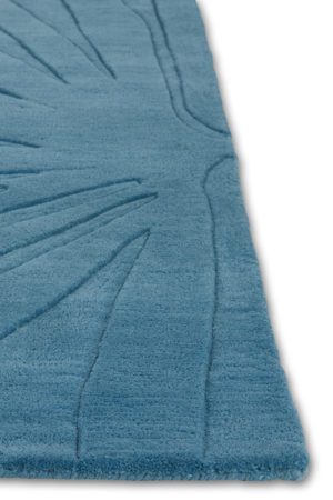 A corner of a modern area rug in blue called Daisies Sky