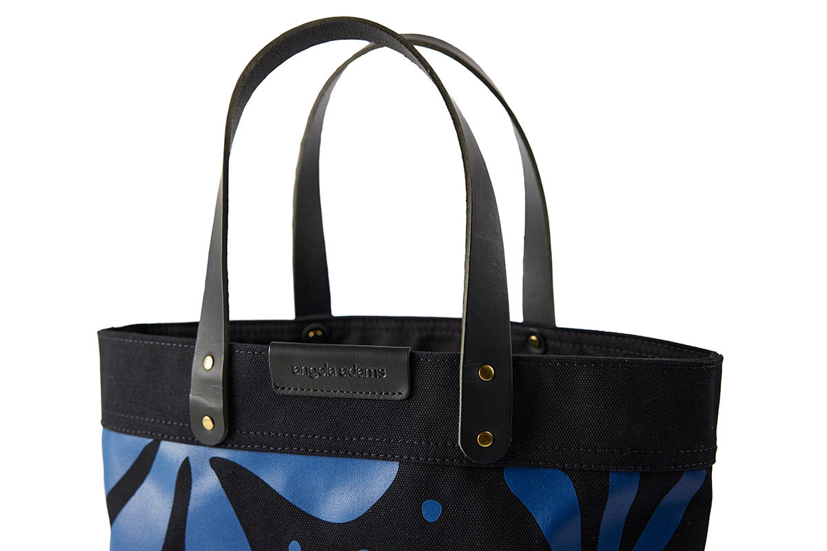 The label and close up of Black and blue Floral print tote by Angela Adams