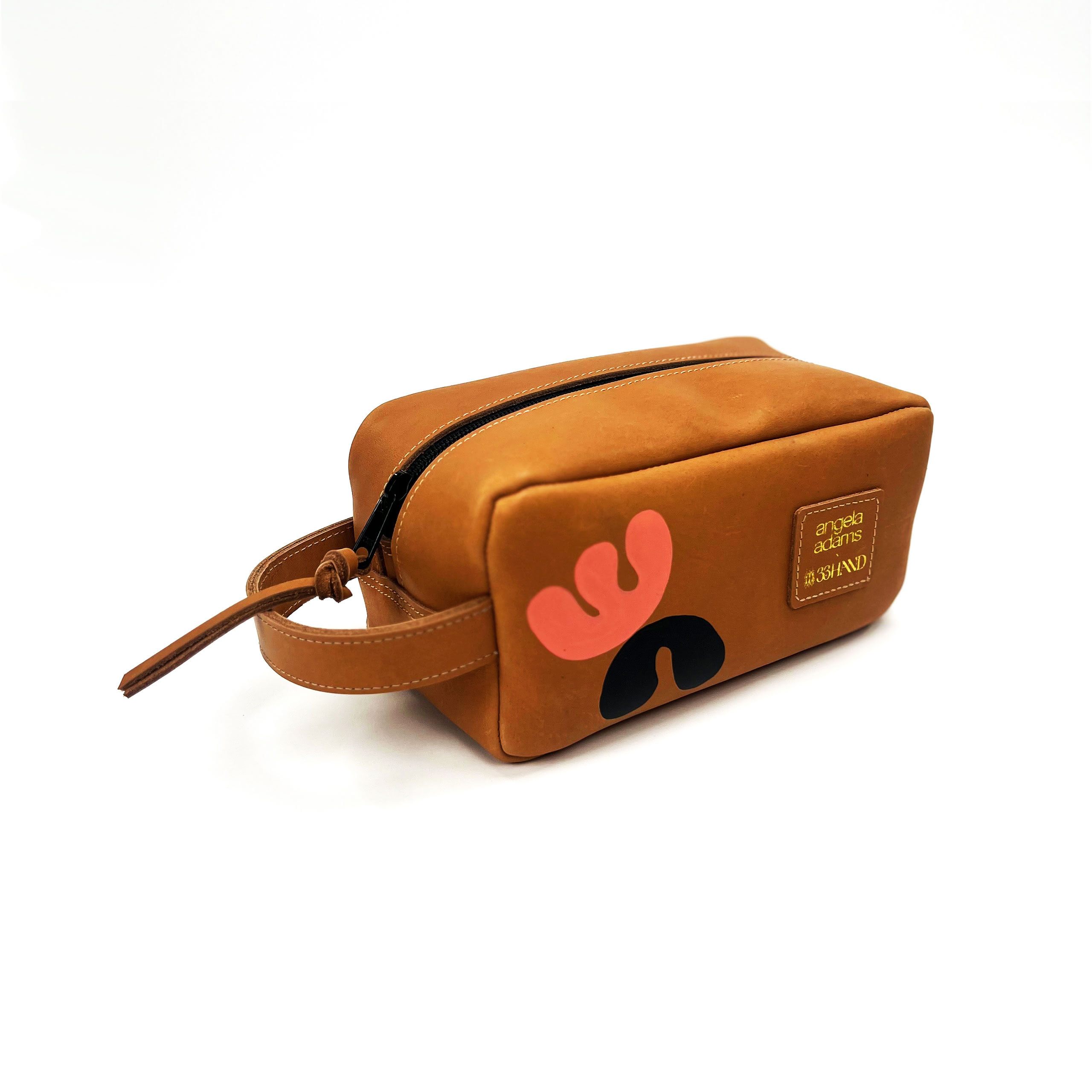 Brown and tan cosmetic bag with a peach handprint logo and text on the side, positioned against a white background.